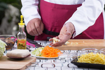 Chef cutting baby corn