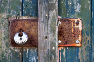 Vintage metal plate with padlock on old wooden door