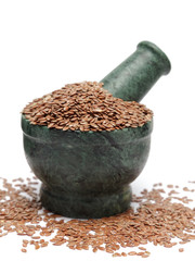 Organic Indian Linseed (Linum usitatissimum) on marble pestle and over white background