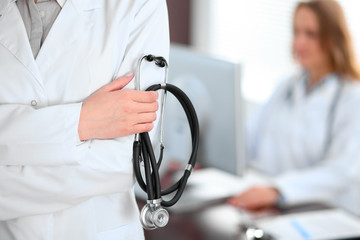 Female doctor standing in a hospital with her colleague in the background