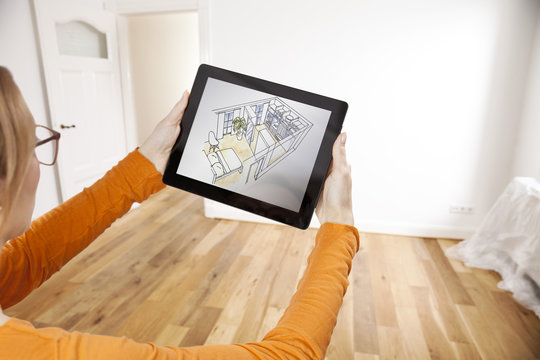 Woman holding interior design sketch in empty apartment