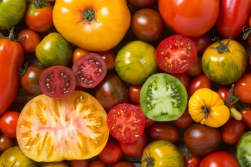 Fotobehang Close up of colorful tomatoes, some sliced, shot from above © kaliantye