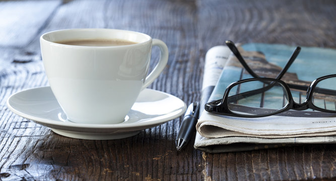 Stack of newspapers with coffee