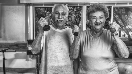 Elder couple making exercises in rehab facility gym