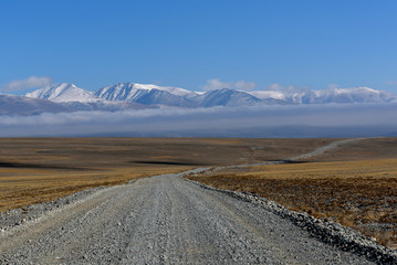 road steppe mountain snow clouds