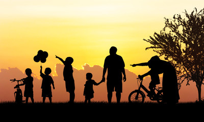 Fototapeta premium Silhouette of Happy family playing in field sunset background