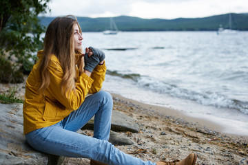 Young woman sitting by the shore