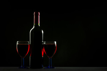 Glasses and bottle of wine isolated on a black background