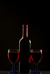Glasses and bottle of wine isolated on a black background