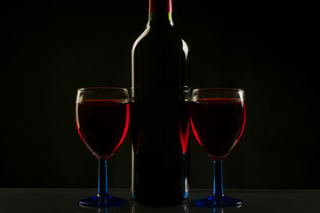 Glasses and bottle of wine isolated on a black background