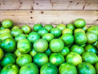 Close up of many green limes on the shelf.