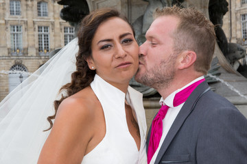 Newly married couple kissing in the city