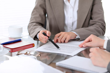 Group of business people and lawyers discussing contract papers sitting at the table, close up