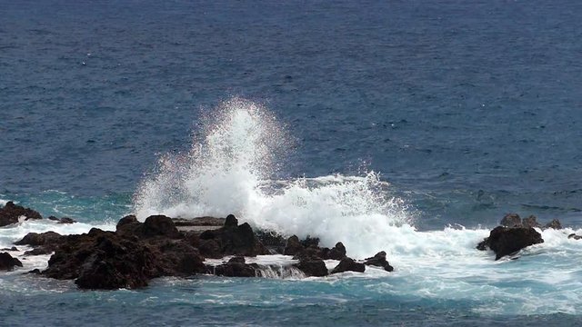 Waves crashing on lava rocks on the coast of the island of La Palma. Two play speed. Slow motion.