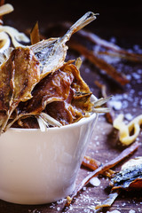 Smoked squid and dried fish. Old wooden background, selective fo