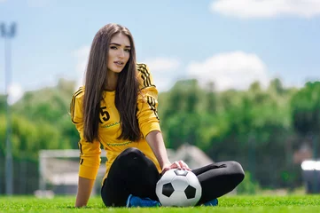Foto op Plexiglas Young sexy woman football player posing on the field © flywish