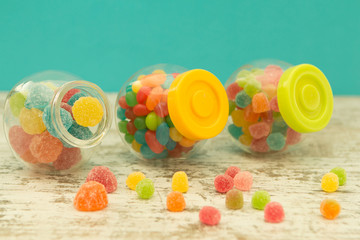 Fototapeta na wymiar Three glass jars full of jellybeans with blue background