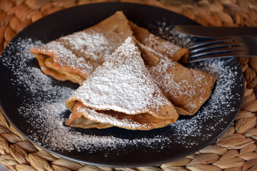 Homemade pancakes with jam and icing sugar.