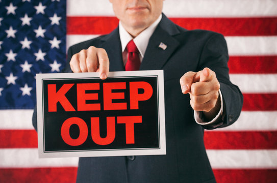 Politician: Man Points At Camera And Holds Keep Out Sign