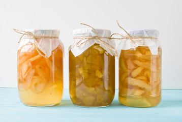 Jam of pears and apples in glass jars on a blue wooden background