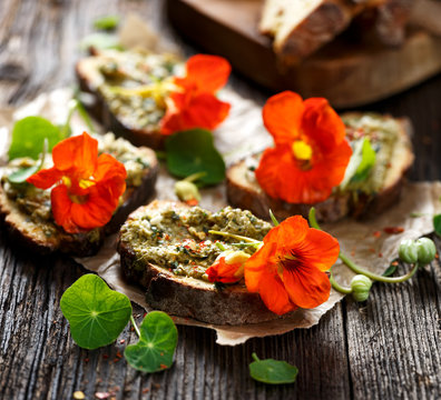 Canapes with herb pesto and edible nasturtium flowers