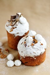 Easter holiday cake kulich with cream nuts dried fruits chocolate cookies marshmallows on craft background