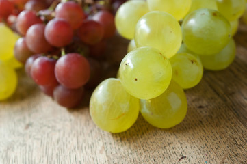 raisin blanc et raison noir sur table en vieux bois