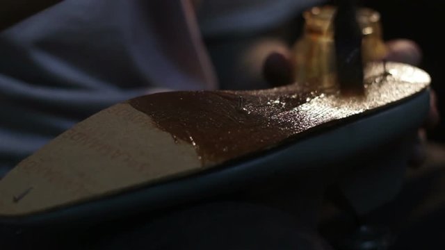 Shoemaker sews shoes, hammering sole