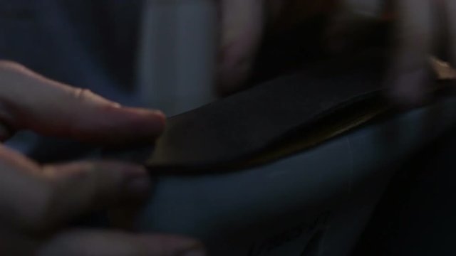 Shoemaker sews shoes, hammering sole