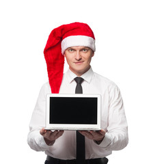 Men in white shirt black tie and red santa claus heat smiling and showing laptop in hands on white isolated background