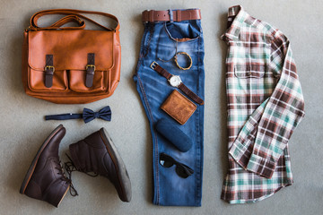 Flat lay of men's casual outfits with accessories on gray background