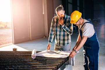 Construction workers checking checking blue print