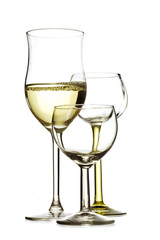 three drinking glasses, one is filled with white wine, the other are empty, isolated on white