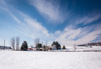 Wispy clouds over a snow covered farm in rural Carroll County, M