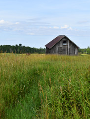 Obraz premium Rustic cabin in a meadow