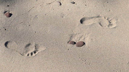 Fototapeta na wymiar Foot prints in warm summer sand