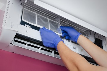 Air conditioner cleaning. Man checks the filter.