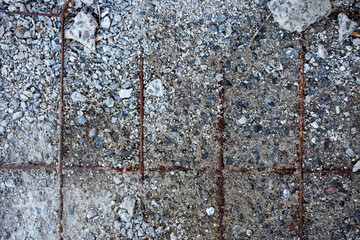 Grey concrete surface with visible reinforcement and crushed sto