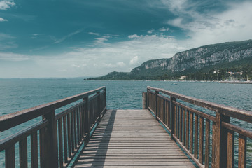 Pier on the Garda lake in a sunny day with clouds