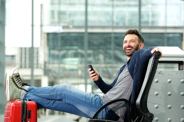 Happy mature man sitting at the train station