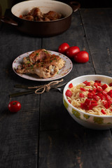 pieces of fried chicken with vegetables and pasta on a able
