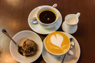 Obraz na płótnie Canvas Cup of black coffee, cup of cappuccino and a milk jug