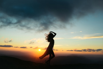 Fototapeta na wymiar woman at sunset or sunrise in mountains