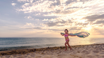 Fototapeta na wymiar happy little girl running on the beach