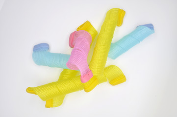 Вертикальные разноцветные бигуди на белом фоне