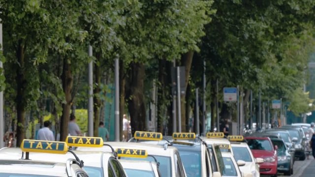 Real time lockdown establishing shot of taxi cars which are waiting for customers in Berlin, Germany. 
