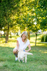 Beautiful girl playing with a puppy labrador.