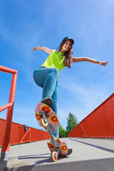 Teen girl skater riding skateboard on street. © Voyagerix
