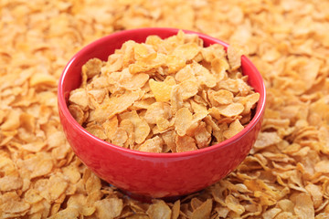 Bowl with corn flakes on corn flakes background