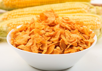 Bowl with corn flakes on white background